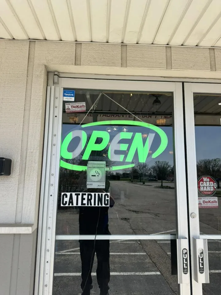 Nina's Tacos storefront with open sign and catering decal