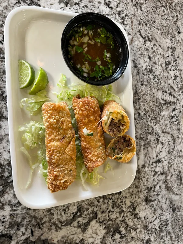 Crispy filled rolls served with consommé, lettuce and lime at Nina's Tacos