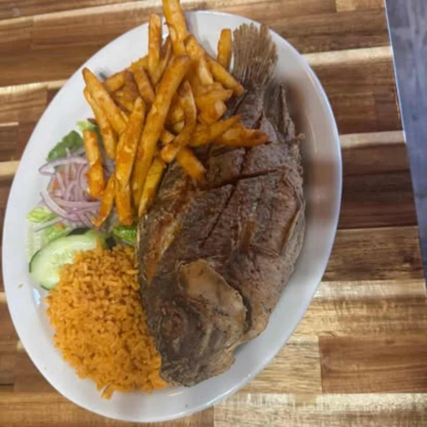 Steak dinner plate with rice, fries, salad, and tortillas at Nina's Tacos