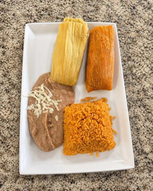 Two wrapped tamales with rice and beans at Nina's Tacos